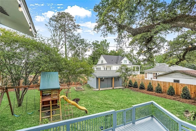 view of yard featuring an outbuilding, a fenced backyard, and a playground