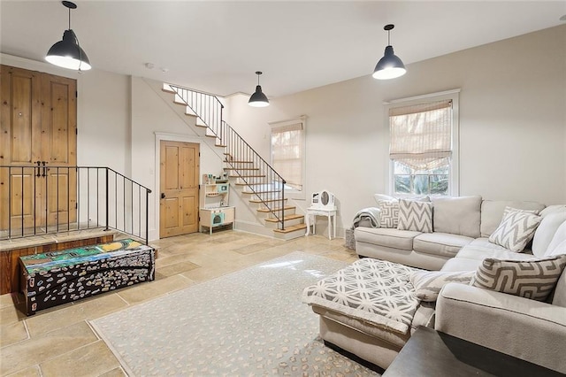 living area with stone tile flooring and stairway