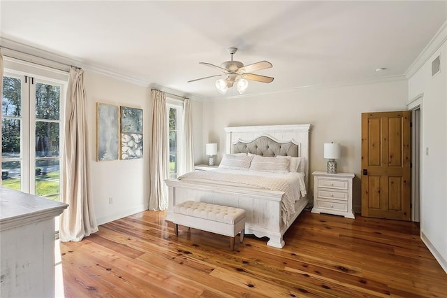 bedroom with crown molding, a ceiling fan, visible vents, and wood-type flooring
