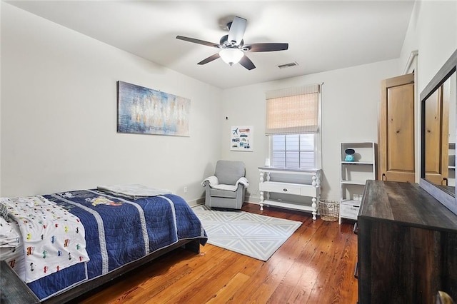 bedroom with wood-type flooring, a ceiling fan, baseboards, and visible vents