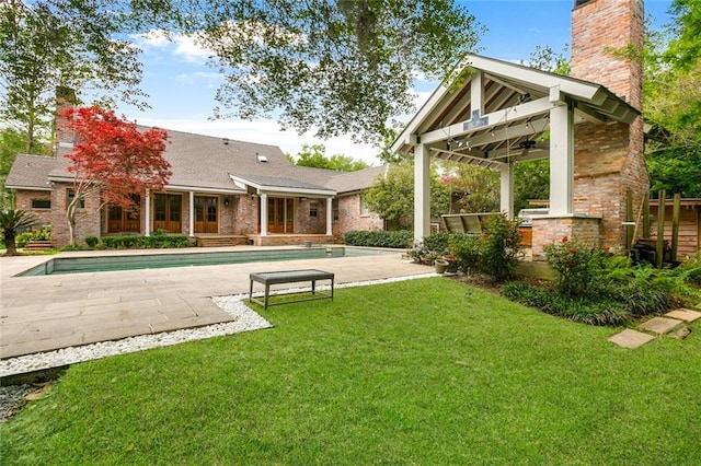 exterior space with a lawn, a pool, and a patio