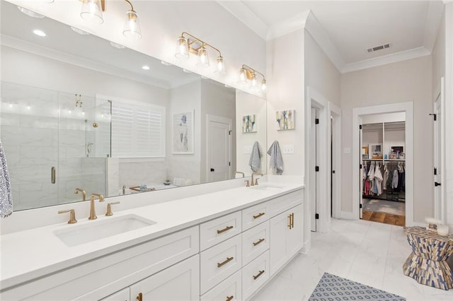 full bath with marble finish floor, ornamental molding, a sink, and a shower stall