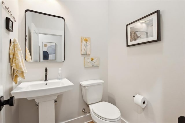 bathroom featuring baseboards and toilet