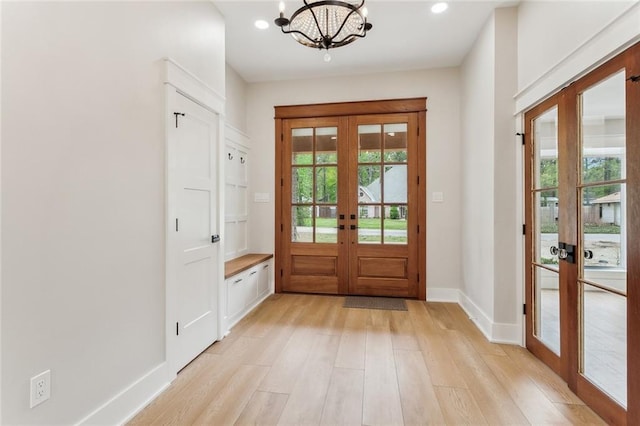 doorway to outside with light wood-type flooring, a healthy amount of sunlight, and french doors