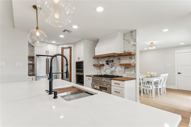 kitchen with recessed lighting, high end appliances, open shelves, backsplash, and visible vents