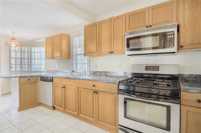 kitchen featuring a sink, a peninsula, stainless steel appliances, beamed ceiling, and decorative backsplash