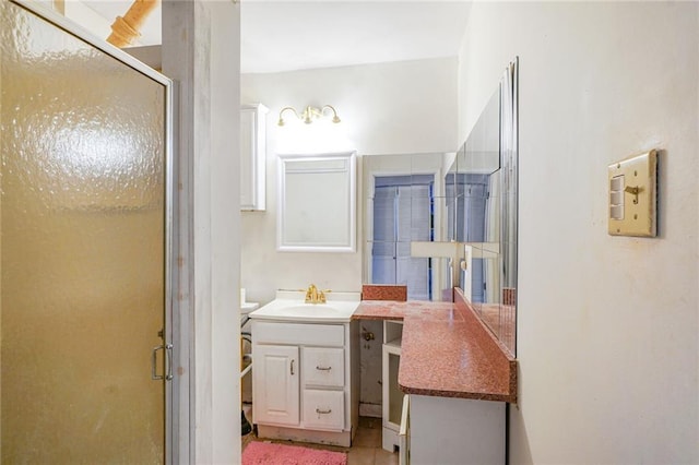 full bathroom with tile patterned flooring, vanity, and a shower stall