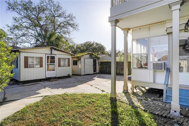 view of yard featuring cooling unit, an outbuilding, concrete driveway, fence, and a storage shed