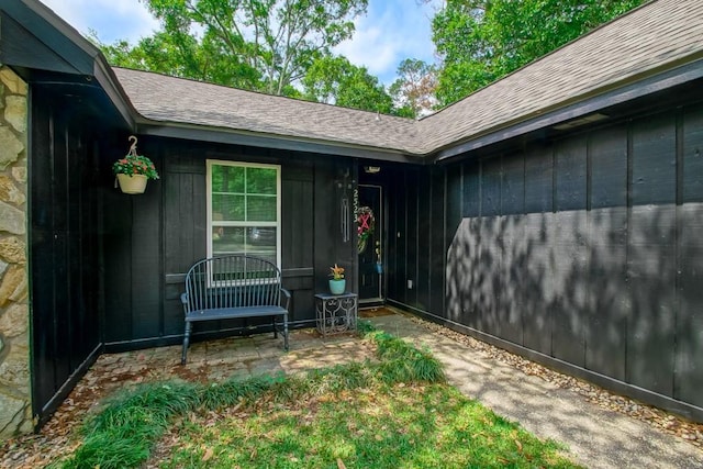 doorway to property featuring a shingled roof