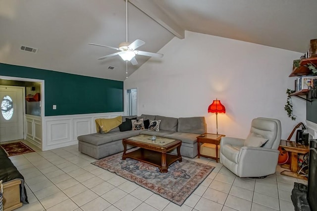 living room featuring light tile patterned flooring, ceiling fan, a wainscoted wall, beamed ceiling, and visible vents