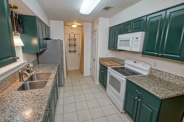 kitchen with white appliances, a textured ceiling, a sink, and green cabinets