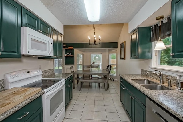 kitchen featuring a textured ceiling, a sink, lofted ceiling, green cabinetry, and white appliances