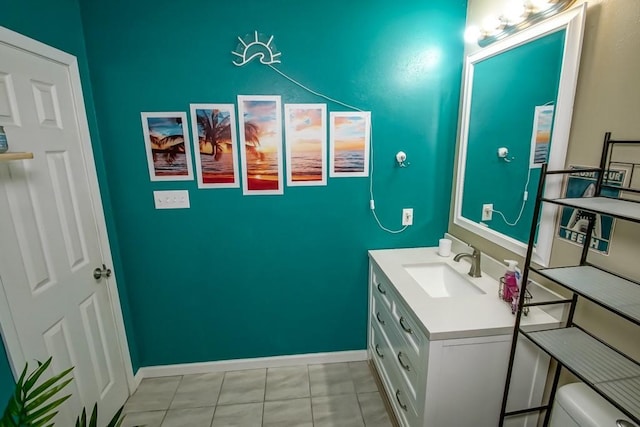 bathroom featuring toilet, baseboards, and vanity