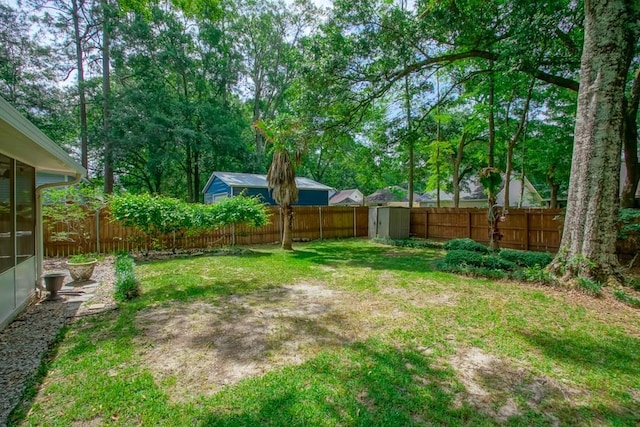 view of yard featuring an outdoor structure, a fenced backyard, a shed, and a sunroom
