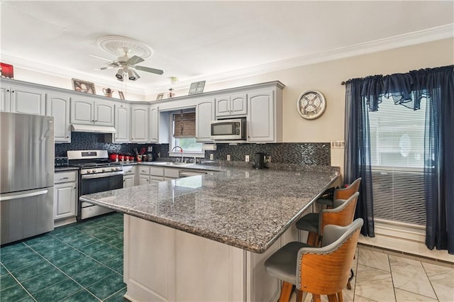 41226 Rene Dr, Hammond, LA 70403 - kitchen with stainless steel appliances, a peninsula, ceiling fan, crown molding, and a kitchen bar