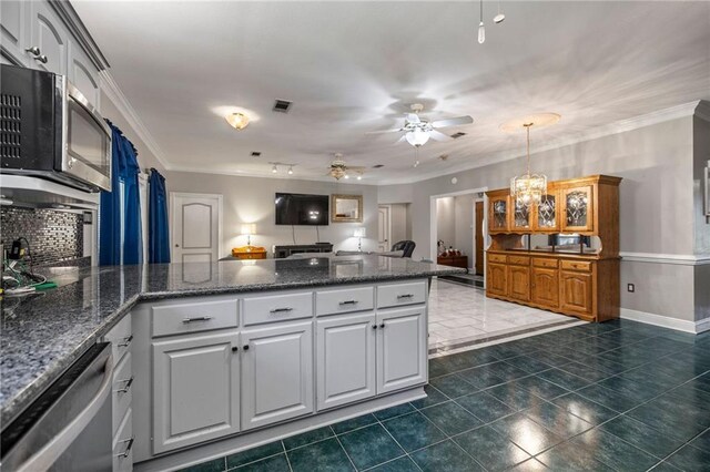 41226 Rene Dr, Hammond, LA 70403 - kitchen featuring appliances with stainless steel finishes, a peninsula, crown molding, dark tile patterned flooring, and white cabinets