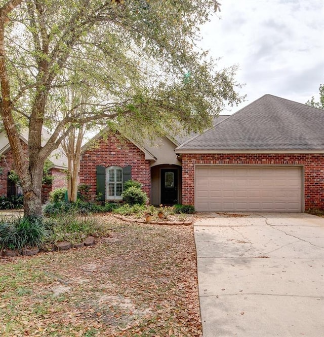 111 Cornerstone Dr Unit 1A, Slidell, LA 70461 - view of front of home with an attached garage, concrete driveway, brick siding, and roof with shingles
