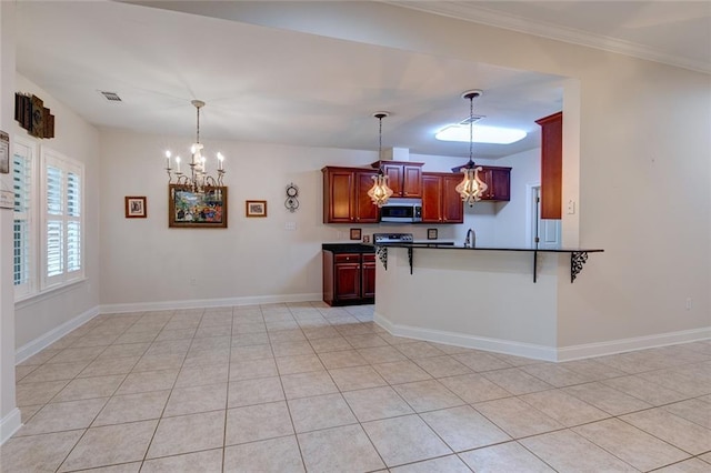 111 Cornerstone Dr Unit 1A, Slidell, LA 70461 - kitchen featuring stainless steel microwave, dark countertops, a chandelier, a breakfast bar, and a peninsula