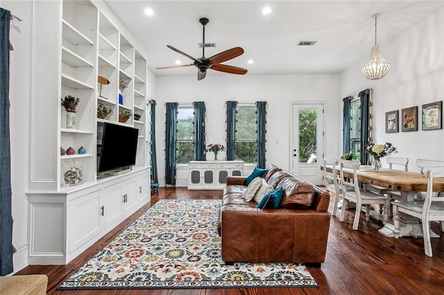 8501 Cohn St, New Orleans, LA 70118 - living area with dark wood-style flooring, a wealth of natural light, visible vents, and ceiling fan with notable chandelier
