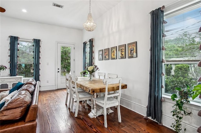 8501 Cohn St, New Orleans, LA 70118 - dining room with baseboards, visible vents, a notable chandelier, and wood finished floors