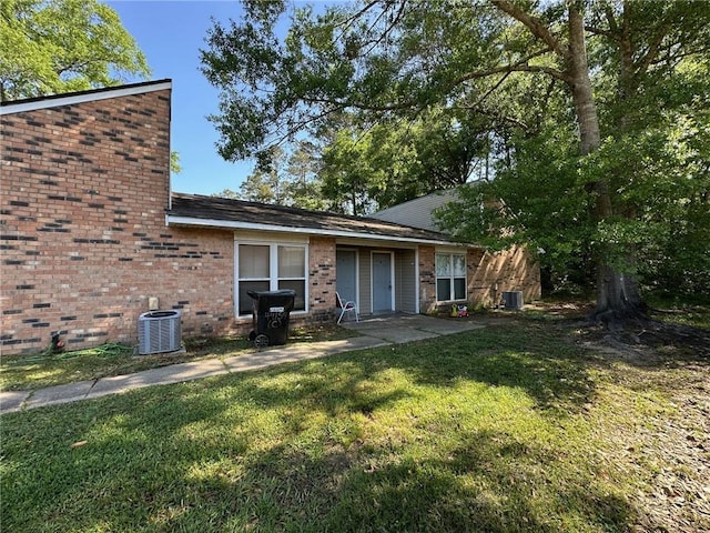 44154 Simpson Pl, Hammond, LA 70403 - back of property with brick siding, a yard, and central AC unit