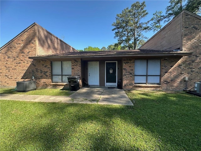 44176 Simpson Pl, Hammond, LA 70403 - back of house featuring a lawn, central AC unit, brick siding, and a patio