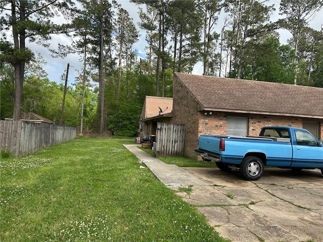 44176 Simpson Pl, Hammond, LA 70403 - view of home's exterior with fence, a shingled roof, brick siding, and a yard