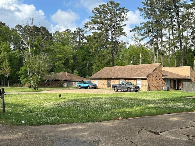 44176 Simpson Pl, Hammond, LA 70403 - view of side of home with dirt driveway, brick siding, a yard, and central AC