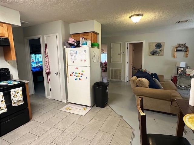 44301 Simpson Pl, Hammond, LA 70403 - kitchen featuring black electric range oven, brown cabinets, visible vents, and freestanding refrigerator