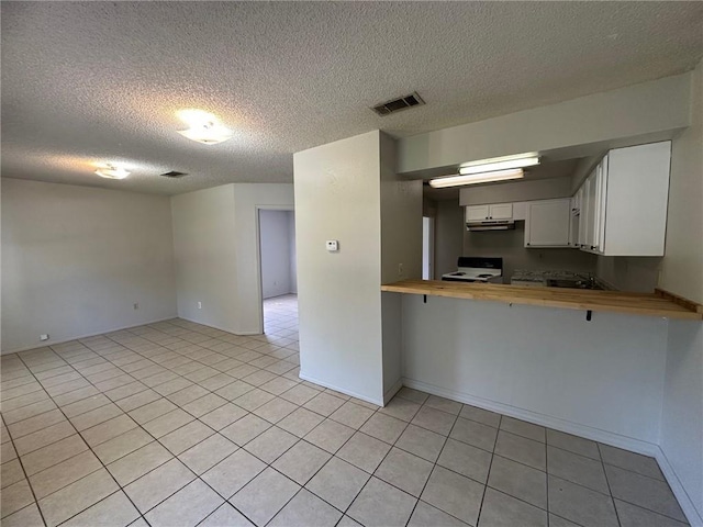 44321 Simpson Pl, Hammond, LA 70403 - kitchen with light tile patterned flooring, electric stove, butcher block counters, and visible vents
