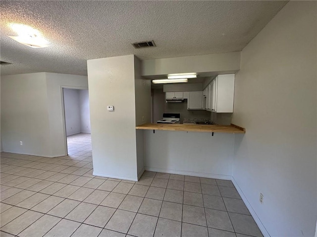 44321 Simpson Pl, Hammond, LA 70403 - kitchen with butcher block countertops, a textured ceiling, visible vents, and light tile patterned floors