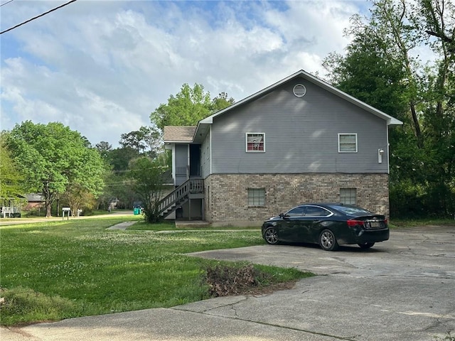 44321 Simpson Pl, Hammond, LA 70403 - view of side of home featuring a lawn, brick siding, driveway, and stairway