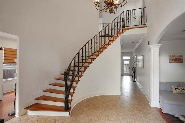 6021 W End Blvd, New Orleans, LA 70124 - staircase featuring arched walkways, tile patterned flooring, decorative columns, a high ceiling, and a chandelier