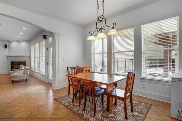 6021 W End Blvd, New Orleans, LA 70124 - dining room featuring crown molding, light tile patterned floors, a premium fireplace, and arched walkways