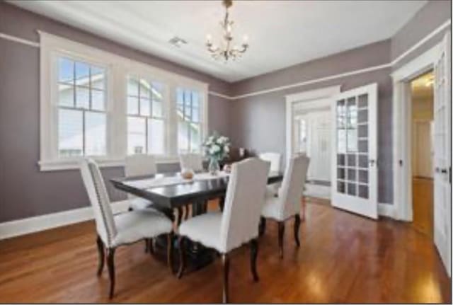 3015 Nashville Ave, New Orleans, LA 70125 - dining room with wood finished floors, an inviting chandelier, and baseboards
