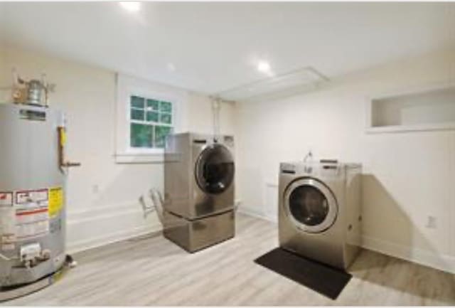 3015 Nashville Ave, New Orleans, LA 70125 - laundry room featuring light wood-style flooring, laundry area, washer and clothes dryer, and water heater