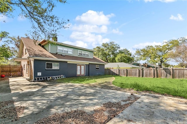 5601 Charlotte Dr, New Orleans, LA 70122 - back of property with a patio, a chimney, a fenced backyard, and a yard