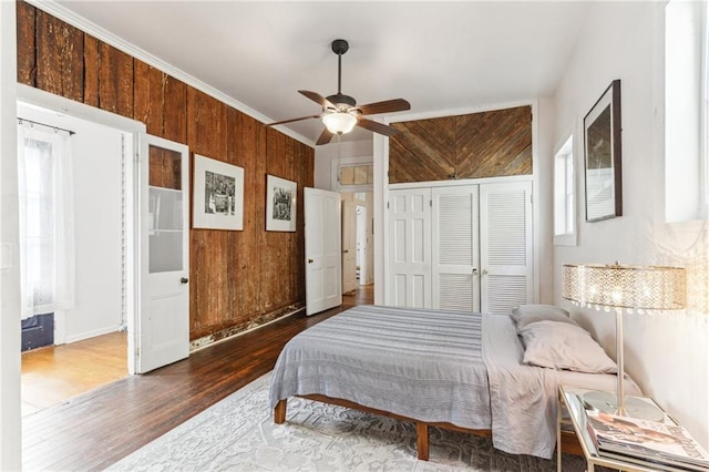 1524 N Dorgenois St, New Orleans, LA 70119 - bedroom featuring wooden walls, wood finished floors, a closet, and ceiling fan