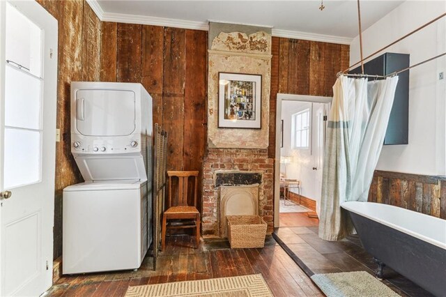 1524 N Dorgenois St, New Orleans, LA 70119 - laundry area featuring stacked washer and clothes dryer, wood-type flooring, ornamental molding, and a fireplace