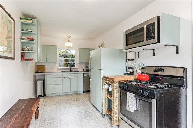 1524 N Dorgenois St, New Orleans, LA 70119 - kitchen with stainless steel appliances, open shelves, light flooring, a sink, and green cabinetry