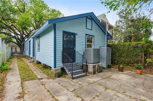 1524 N Dorgenois St, New Orleans, LA 70119 - rear view of house featuring cooling unit, entry steps, fence, and a patio