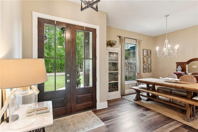 entryway with baseboards, a notable chandelier, wood finished floors, and french doors