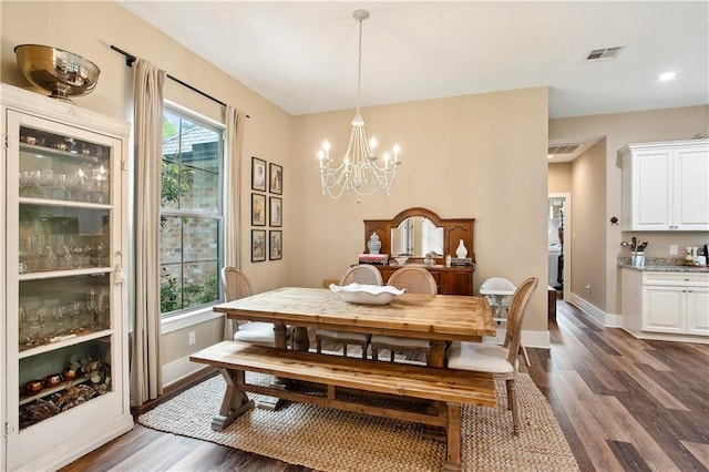 dining area featuring dark wood-style floors, visible vents, a notable chandelier, and a wealth of natural light