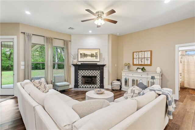 living area with recessed lighting, visible vents, a tile fireplace, ceiling fan, and wood finished floors