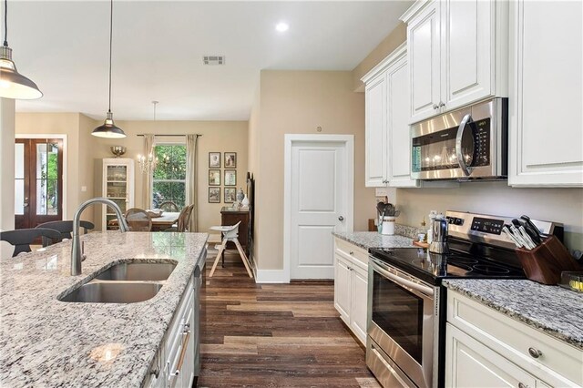 kitchen featuring white cabinets, visible vents, stainless steel appliances, dark wood-type flooring, and a sink