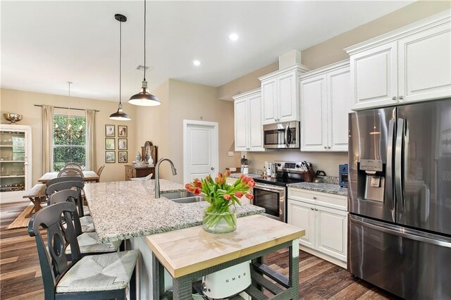 kitchen with dark wood-style flooring, white cabinetry, a sink, and stainless steel appliances