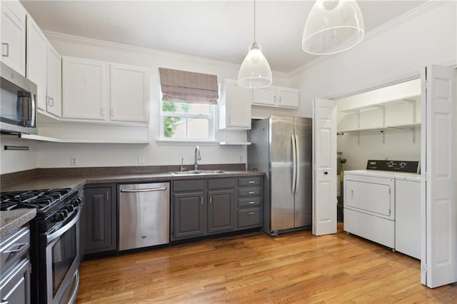 7464 Pitt St, New Orleans, LA 70118 - kitchen with appliances with stainless steel finishes, washing machine and dryer, dark countertops, crown molding, and gray cabinets