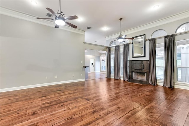 unfurnished living room featuring wood finished floors, ceiling fan, a fireplace, and ornamental molding