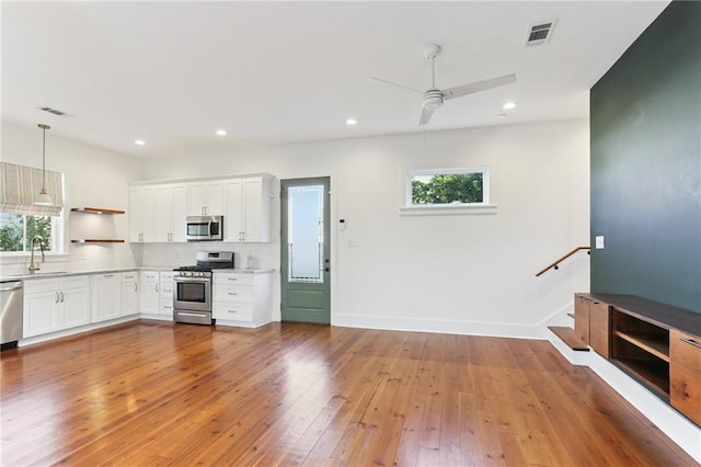 1217 N Tonti St, New Orleans, LA 70119 - kitchen with appliances with stainless steel finishes, light countertops, ceiling fan, open shelves, and decorative backsplash