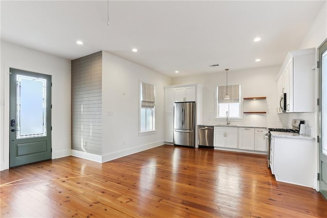 1217 N Tonti St, New Orleans, LA 70119 - kitchen featuring stainless steel appliances, plenty of natural light, open shelves, light wood-style flooring, and recessed lighting